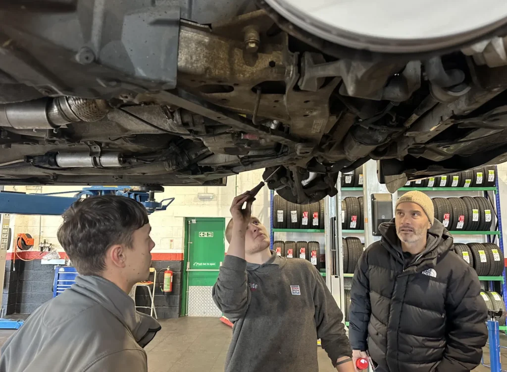Elite Garages' technicians and Joe Achilles inspecting the 250k-mile BMW 320D