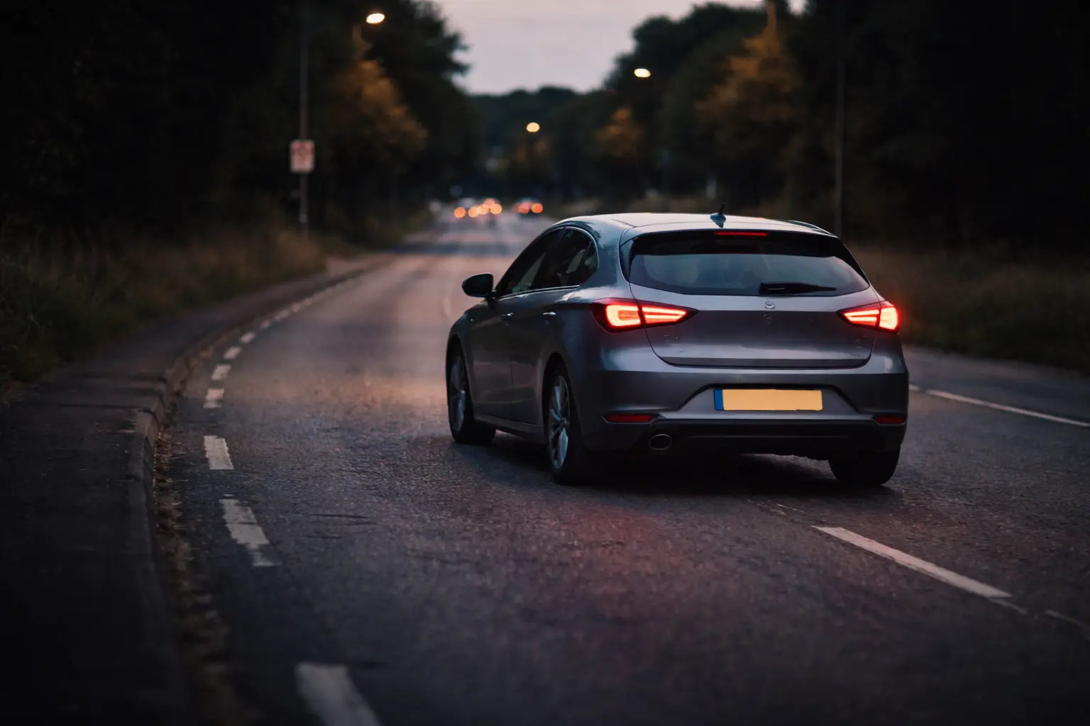 Car driving slightly off-centre with front wheels turned, illustrating steering correction caused by alignment or steering issues.